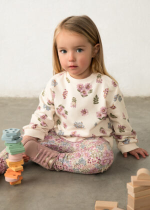 Mayoral girls’ cream sweatshirt with an all-over pink, purple and blue floral print, long sleeves, ribbed cuffs, crew neckline and dipped hem.