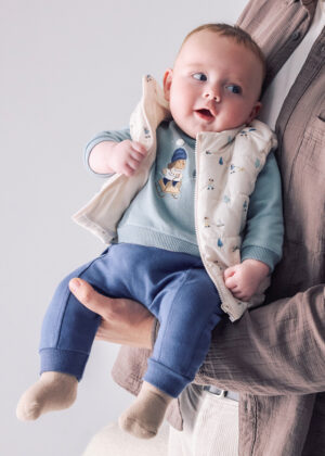 Baby boys’ three-piece outfit featuring a cream printed padded gilet, sage green character sweatshirt, and navy blue joggers