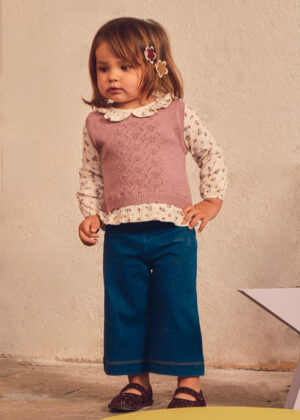 Girls’ three-piece outfit featuring a dusty pink knitted vest with an openwork pattern, a cream long-sleeve floral blouse with a ruffled collar, and blue wide-leg denim jeans.
