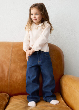Close-up of girls’ dark blue wide-leg denim jeans featuring a button fastening, belt loops, front pockets, and contrasting golden-brown stitching.
